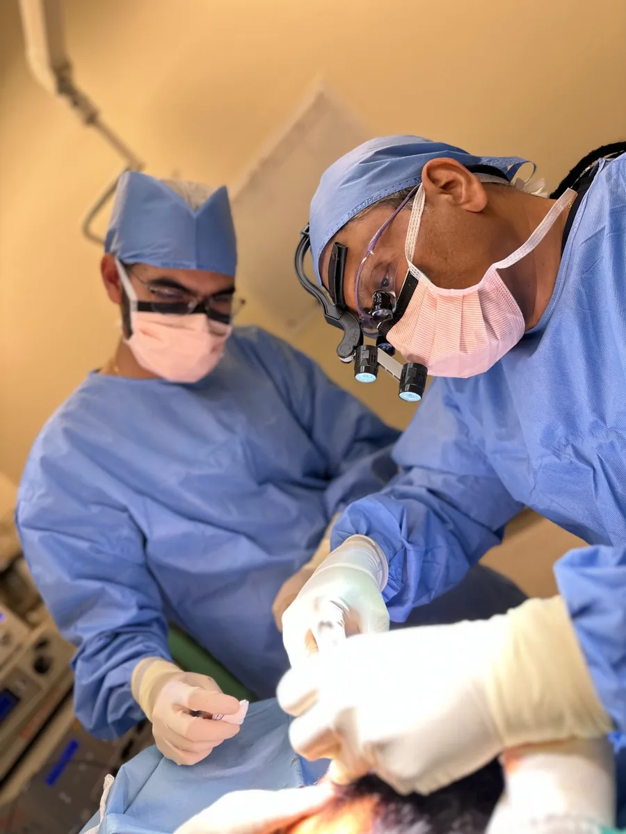 Dr Sanjay Parashar operating, wearing surgical loupes
